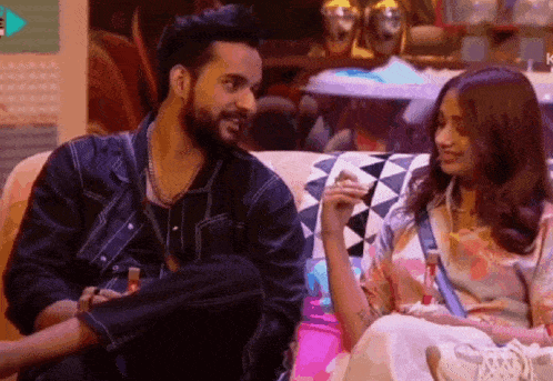 a man and a woman are sitting on a couch .