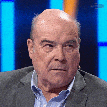 a bald man in a suit and a blue shirt is sitting in front of a blue background with the word passwair on it