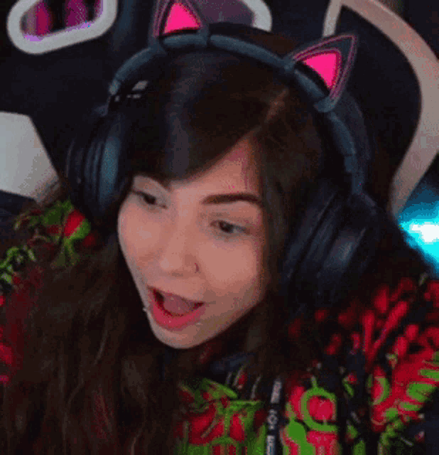 a woman wearing headphones with cat ears is sitting in a chair .