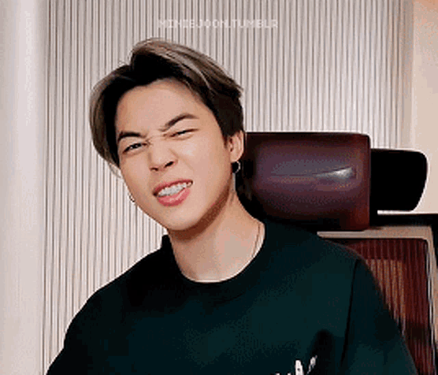 a young man is making a funny face while sitting in a chair