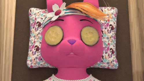 a pink stuffed animal with cucumber slices on her eyes