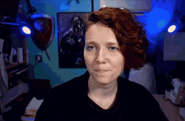 a woman with red hair and a nose ring is smiling