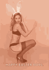 a woman in lingerie and bunny ears is squatting down and says `` happy easter boys '' .