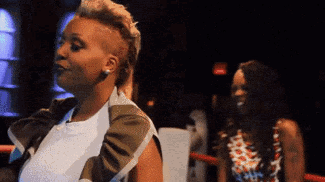 two women are standing next to each other and one has a mohawk on her head