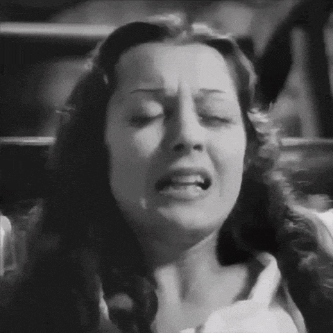 a black and white photo of a woman with her eyes closed and her mouth open .
