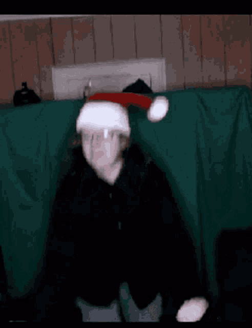 a man is wearing a santa hat and making a funny face