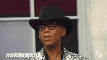 a man wearing a black hat and glasses is making a face .