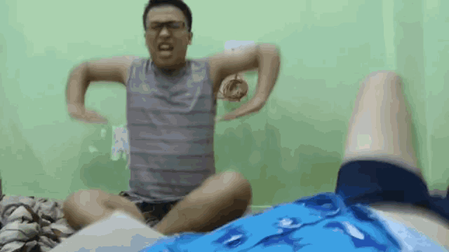 a man is sitting on a bed with his legs crossed and his arms outstretched .