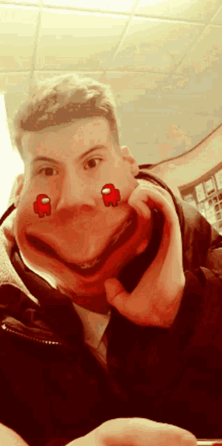 a man is making a funny face with two red among us characters on his face