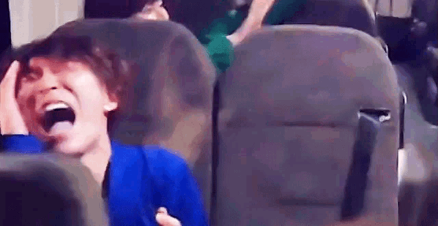 a person is sitting in a chair with their mouth open and laughing .