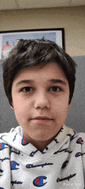 a young boy is wearing a white champion sweatshirt
