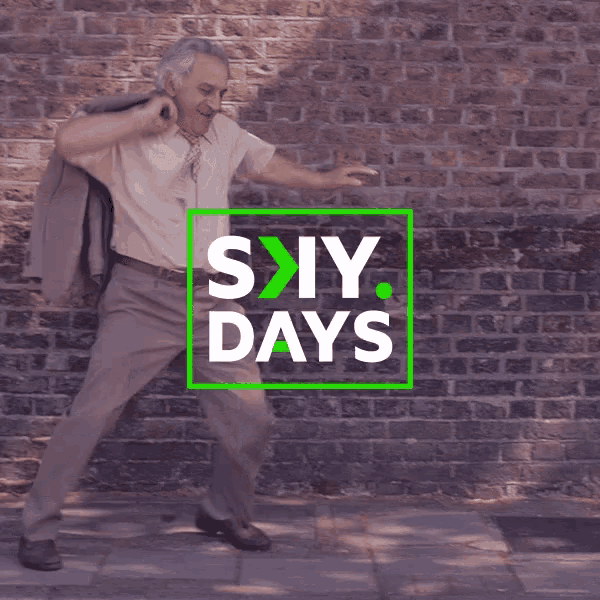 a man in a suit and tie is walking in front of a brick wall with the words six days written on it