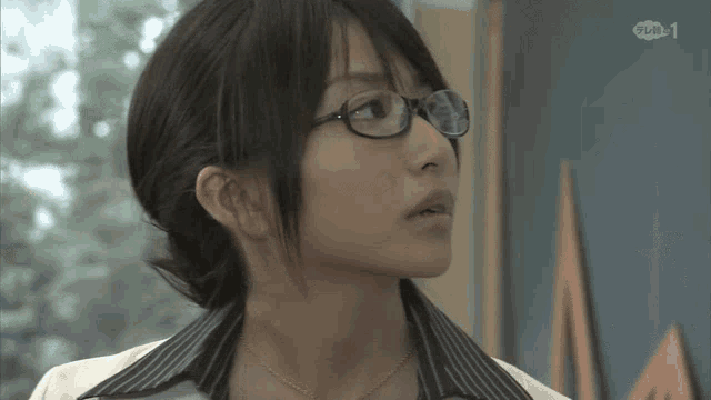 a woman wearing glasses and a striped shirt has the number 1 on the bottom right