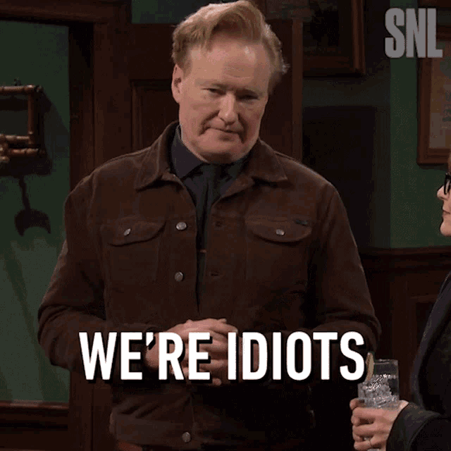 a man says we 're idiots while holding a glass of whiskey