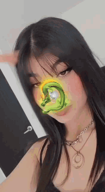 a woman with long black hair is wearing a necklace and a mask with a dragon on it .