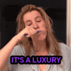 a woman brushing her teeth with the words it 's a luxury