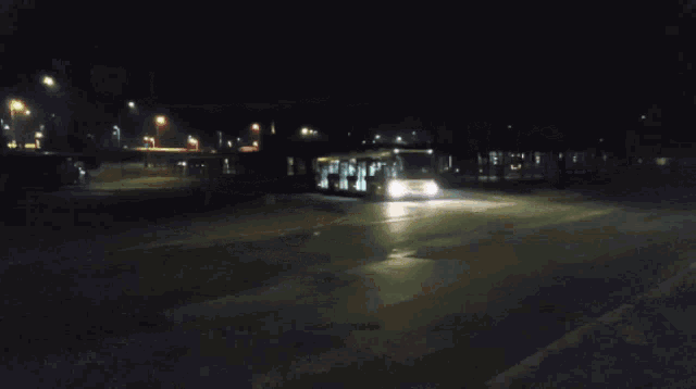 a bus is driving down the road at night