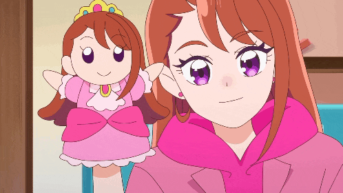 a girl in a pink jacket is holding a pink doll with purple eyes