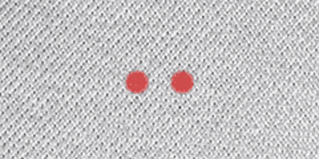 a close up of a white fabric with two red circles on it .