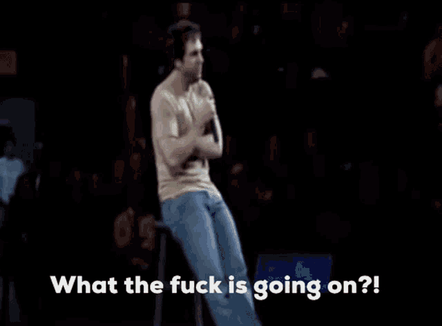 a man is dancing on a stage with the words `` what the fuck is going on ? '' written below him .