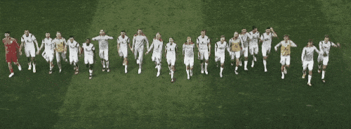 a group of soccer players are lined up on a field holding hands