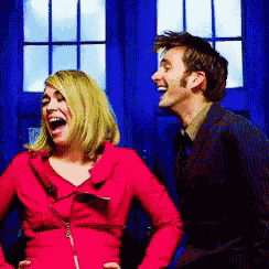 a man and a woman are laughing in front of a blue wall