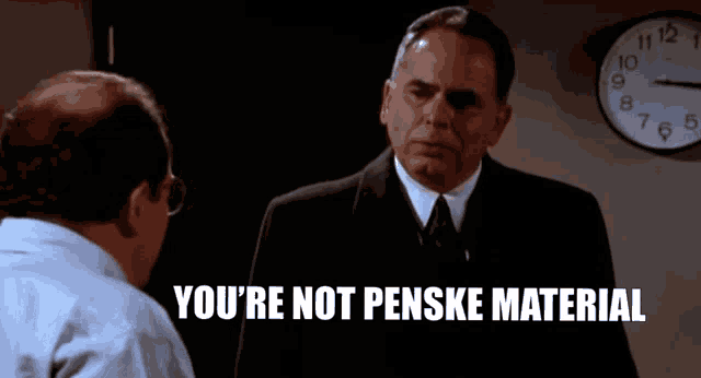 two men are talking in front of a clock that says you 're not pense material