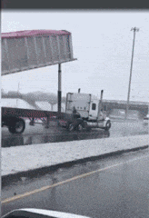 a truck is parked on the side of a road in the rain