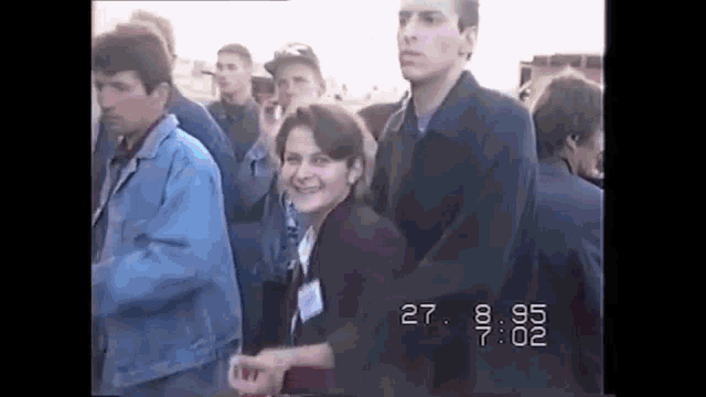 a group of people are standing next to each other in a crowd .