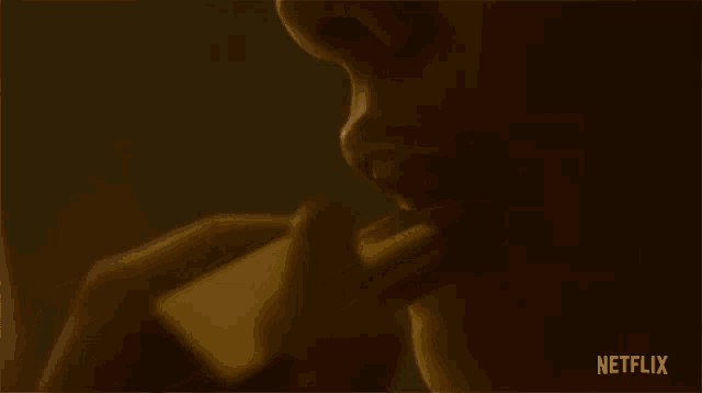 a close up of a person applying lipstick with a netflix logo in the background