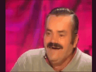 a man with a mustache is making a funny face while sitting in front of a pink background .