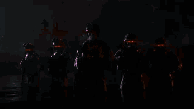 a group of soldiers standing around a fire in the dark .