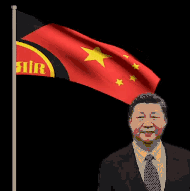 a man in a suit and tie is standing in front of a flag that says fair