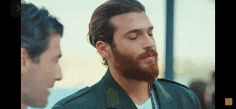 a man with a beard wearing a green jacket