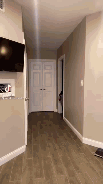 a hallway with a tv mounted on the wall and a tiktok sticker on the wall
