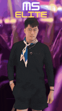 a man wearing glasses and a scarf is standing in front of a ms elite sign