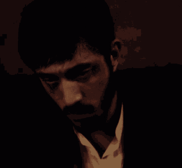 a close up of a man 's face with a beard looking up