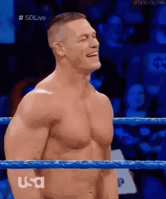 john cena is standing in a wrestling ring without a shirt on .