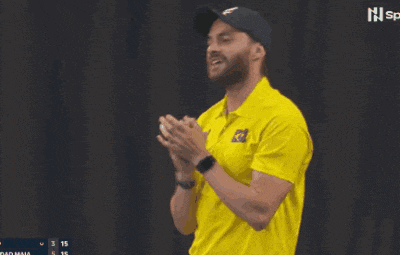 a man wearing a yellow shirt with a brazilian flag on it applauds