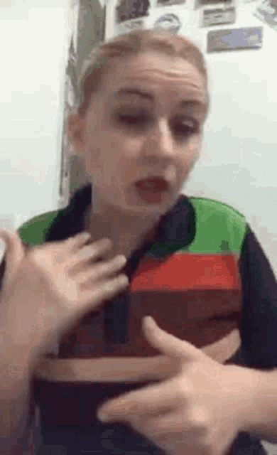 a woman in a burger king uniform is making a funny face while talking to someone .