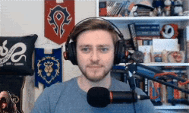 a man wearing headphones stands in front of a microphone in a room