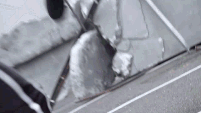 a person is shoveling snow off the side of a road .