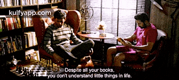 two men sit at a table reading books and playing chess with a quote from kulfyapp.com
