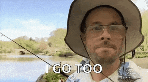 a man wearing a hat and glasses is fishing in a lake .