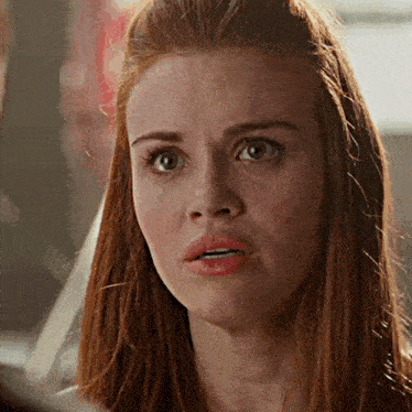 a close up of a woman 's face with red hair