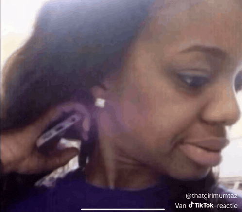 a woman is talking on a cell phone while wearing earbuds .