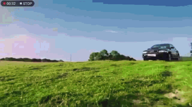 a car is driving down a grassy hill with a stop button on the bottom