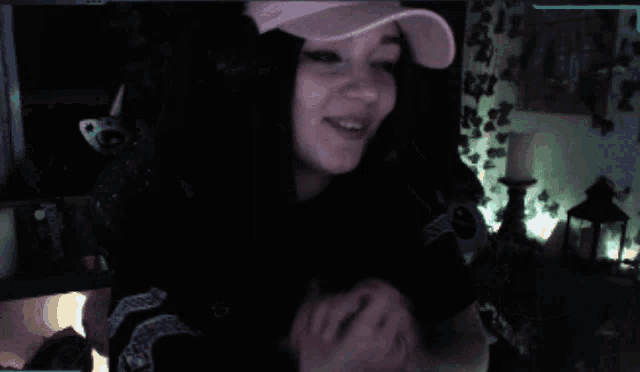 a woman wearing a pink hat is smiling and waving