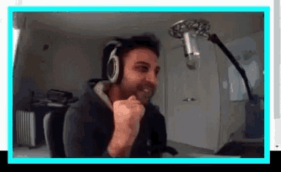 a man wearing headphones is sitting in front of a microphone and making a funny face .
