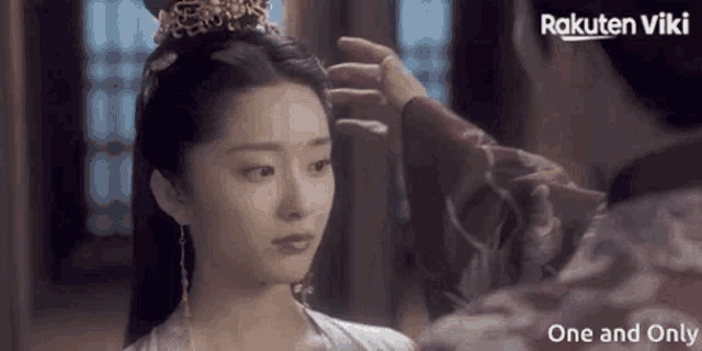a woman with a crown on her head is being touched by a man in a rakuten viki advertisement